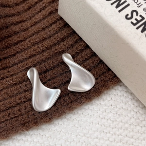 Macro shot of matte silver earrings with abstract streamlined organic geometric design