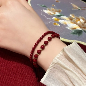 Ensemble de bracelets vintage en perles rouges et or porté au poignet avec dentelle