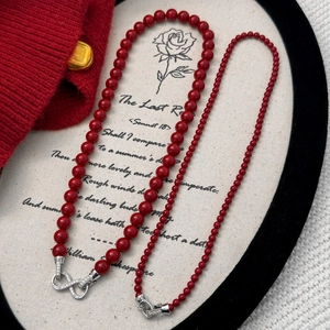 Detalle del collar de doble capa de cuentas rojas con cierre infinity de lujo y cristal