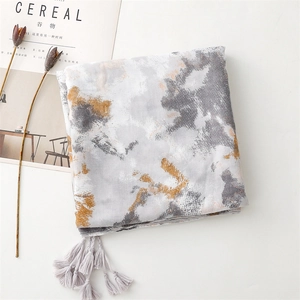Detailed view of gray ink wash scarf with delicate purple tassels and artistic print