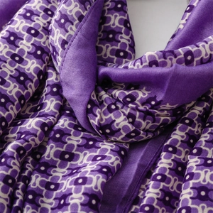 Macro shot of purple geometric chain pattern on soft silk-like scarf fabric