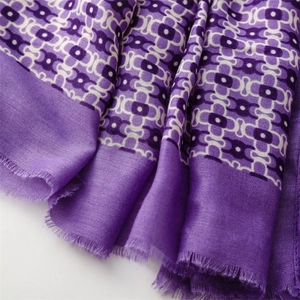 Macro view of soft purple geometric pattern scarf with delicate frayed edges detail