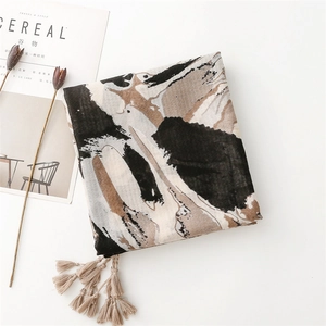 Detail of artistic cotton linen scarf with abstract print and fringe tassels for women