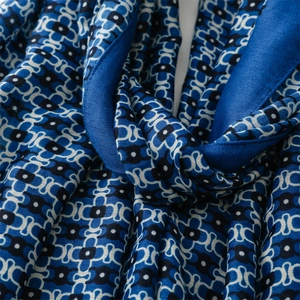 Close-up of the smooth, sapphire blue geometric pattern fabric with fine rolled edges