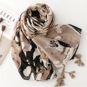 Detail of soft vintage abstract print shawl with elegant tassel fringe on white background
