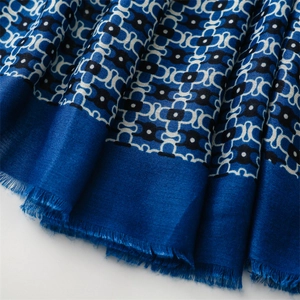 Macro view of geometric chain jacquard pattern on soft navy scarf with fringe edges