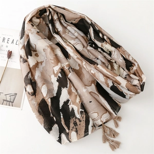 Abstract print scarf with earthy tones and fringes, styled with minimalist magazine props