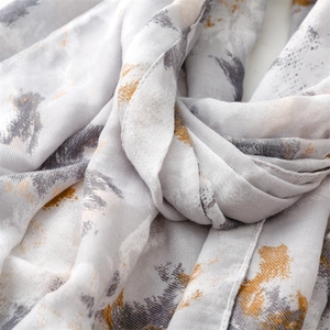 Macro detail of breathable cotton linen scarf with abstract ink print and textured weave