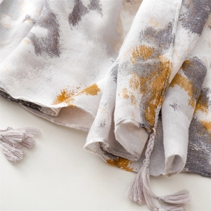 Detail of grey and yellow ink wash pattern scarf with soft fringe and fine texture