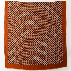 Close-up of geometric pattern and frayed fringe on red-brown cotton-linen feel scarf