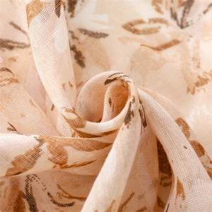 Macro detail of lightweight linen-feel scarf showing bohemian leaf pattern and texture