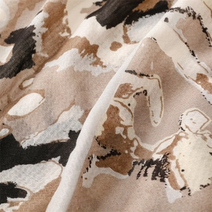 Close-up detail of soft cotton linen scarf showing abstract ink print and fiber texture