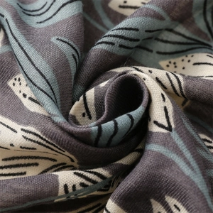 Gros plan sur l'écharpe épaisse en coton satiné avec motifs floraux et texture douce