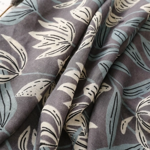Texture détaillée du châle épais en coton et lin avec motifs floraux gris et franges
