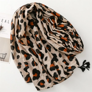 Fashionable leopard print scarf with fringe edges displayed on a white minimalist background