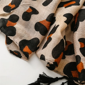 Detail shot of leopard print scarf with black tassels and breathable cotton texture