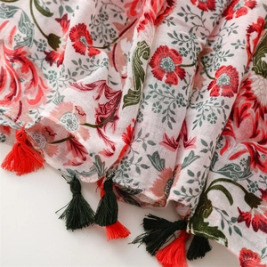 Detail of floral print scarf showing cotton linen texture and red green tassels