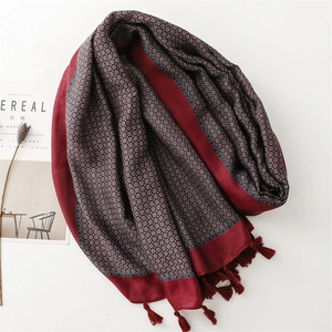 Sciarpa invernale rosso scuro con motivi geometrici floreali e bordi con nappe