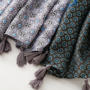 Close-up of winter thick scarf showing geometric print patterns and fringe tassels