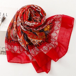 Detailaufnahme des roten Boho-Schals mit geometrischen Sonnenmustern und Spitzenkanten