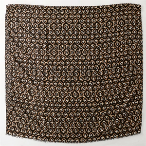 Close-up of bohemian square shawl with geometric floral pattern and fringe edge detail