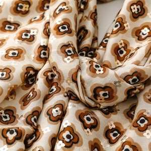 Macro shot of cotton linen scarf featuring vintage floral patterns with gold foil details