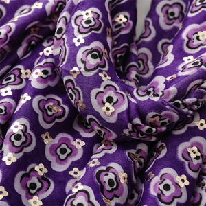 Close-up of purple floral scarf with golden foil flower details and soft draped texture