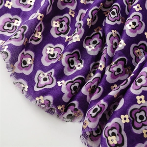 Detailed macro view of purple floral pashmina scarf with gold foil accents and fringe trim
