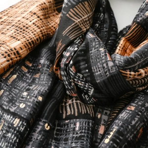 Detailed view of scarf with gold foil printing and geometric architectural patterns