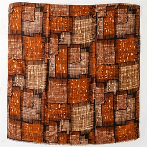 Detail of cotton-linen scarf with geometric block patterns and natural fringe edges