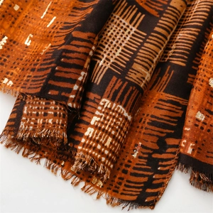 Detailed view of scarf featuring gold spiderweb pattern and soft tassel edges