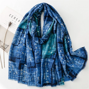 Blue geometric patchwork scarf with gold foil dots and fringe edges on white background