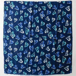 Vue détaillée d'une écharpe en satin bleu foncé avec des motifs de cœurs abstraits