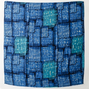 Close-up of blue geometric patch pattern scarf with delicate fringed edge detail