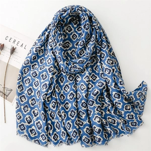Dark blue linen scarf with beige camellia print and frayed edges on white background