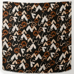 Détail d'une grande écharpe carrée noire avec motifs de cœurs et bords effilochés