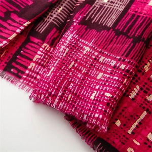 Detail of vibrant red and purple cotton linen scarf with gold foil dots and frayed edges
