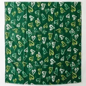 Détail d'écharpe en coton et lin vert vintage avec motifs cœurs dorés et franges