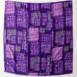 Detailed close-up of purple geometric grid pattern and tassel edges on the scarf shawl