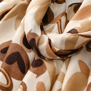 Gros plan d'un tissu soyeux avec motifs cœurs beiges et finitions d'ourlets fins