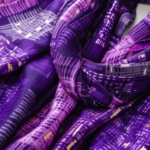 Detailed macro view of purple fabric with golden foil patterns and soft draped texture