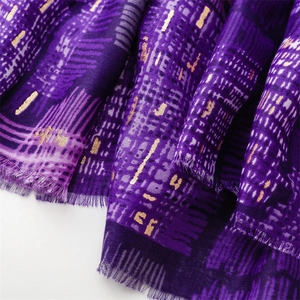 Detail of dark purple scarf with gold foil spider web pattern and fringe edges