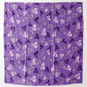 Détail du motif à cœurs violets sur tissu en coton-lin avec bords à franges