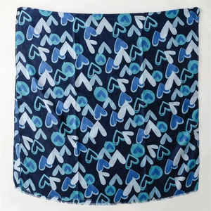 Gros plan du motif cœur bleu abstrait sur une écharpe carrée avec bords effilochés