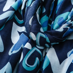 Vue rapprochée de motifs de cœurs géométriques abstraits sur un foulard bleu en coton