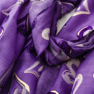 Détail macro du châle violet foncé avec motif de cœurs dorés et texture soyeuse