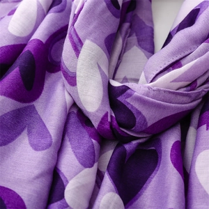 Gros plan du motif cœur violet sur le tissu doux d'une écharpe d'hiver en lin