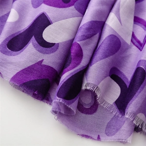 Détail d'une écharpe violette à motif cœur avec texture coton-lin et bords effilés