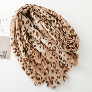 Fashionable leopard print scarf with fringe edges in earthy tones on a white background