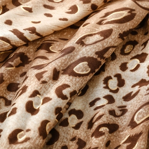 Detail of leopard print fabric with golden foil sketching on beige linen-feel scarf